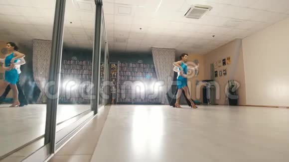 年轻漂亮的男人和女人穿着服装在工作室跳舞和练习拉丁舞视频的预览图
