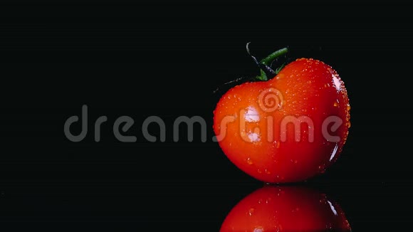 新鲜洗过的西红柿表面是黑色的背景一滴水的近距离流动在视频的预览图