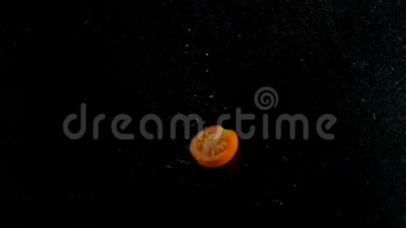 红西红柿在水里飘落黑色背景视频的预览图