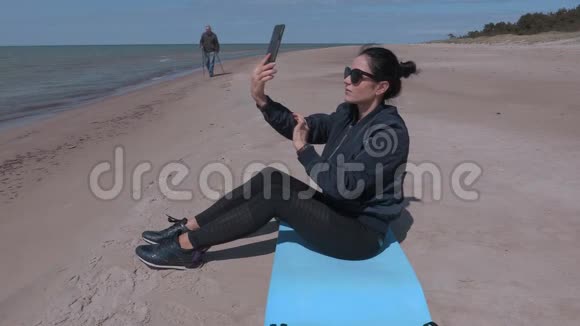 坐在沙滩上自拍的女人视频的预览图