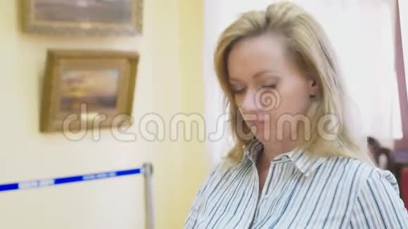 俄罗斯索契2018年9月28日索契市美术馆社论一个优雅美丽的女人看着视频的预览图