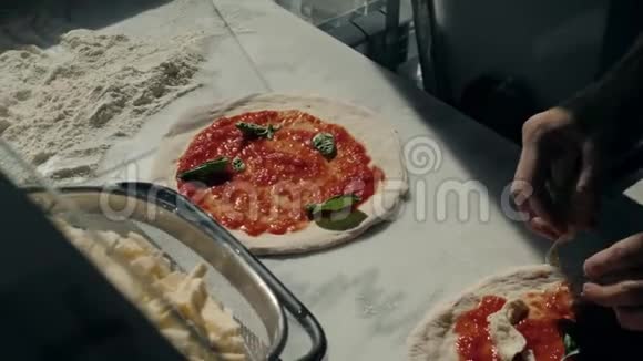 餐厅的厨师准备了一份披萨并用番茄拉和罗勒装饰视频的预览图