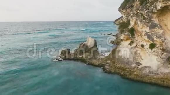 宁静迷人的岩石地形覆盖着草和蓝色的海洋视频的预览图