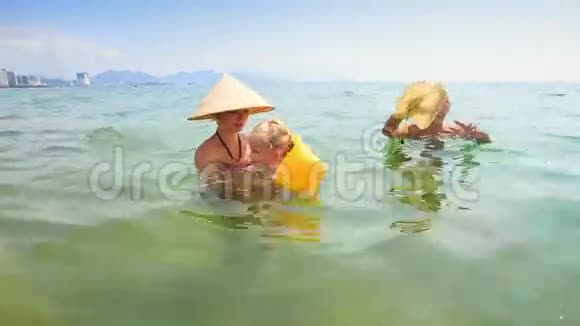 在海中从母亲游到爷爷的小女孩视频的预览图