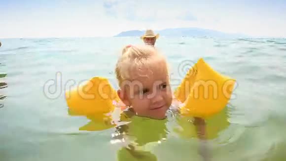 在海中从母亲游到爷爷的小女孩视频的预览图