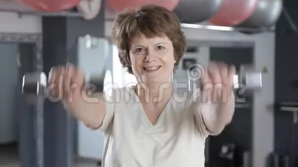 老年女性提哑铃成熟健身视频的预览图