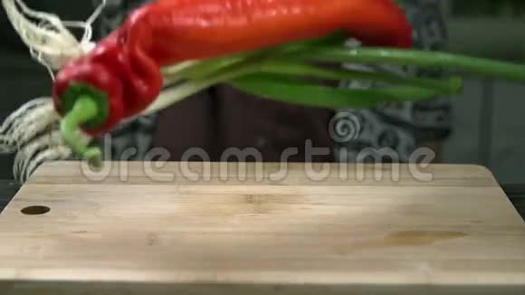 大辣椒和洋葱掉在木桌上视频的预览图