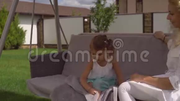 女人和孩子在后院的房子里享受夏天视频的预览图