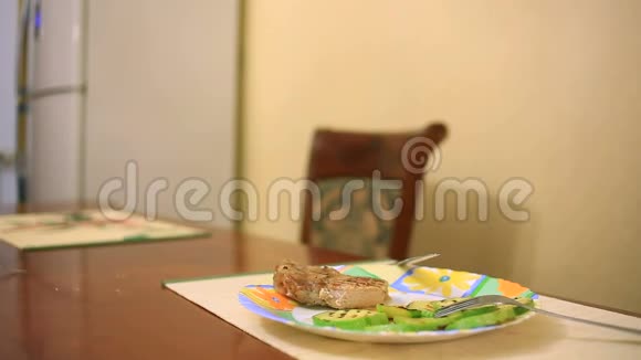 一个男人在家庭环境中吃牛排特写视频的预览图