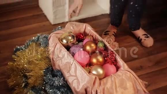 两个微笑的小女孩在家里的新年树上装饰圣诞装饰品圣诞树用冷杉锥新视频的预览图