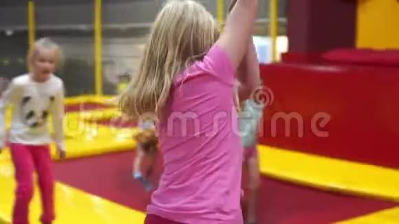 城市现代儿童的快乐童年蹦床公园里的女孩视频的预览图
