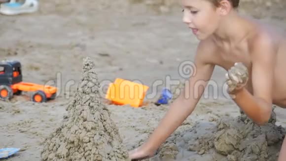 儿童正在缓慢地在海滩上建造一座沙堡视频的预览图