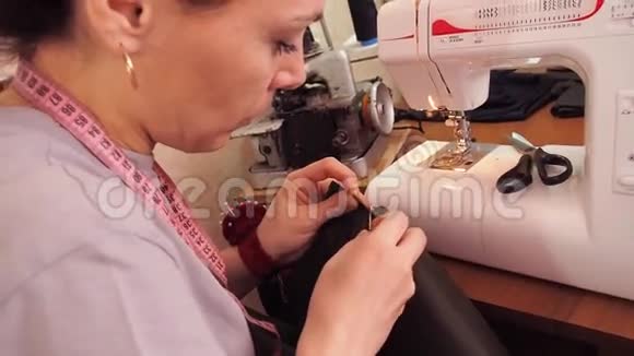裁缝裁剪布料女孩用剪刀剪布料织物上的刺针视频的预览图