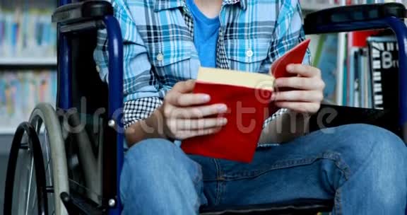 图书馆里坐轮椅看书的残疾学童视频的预览图