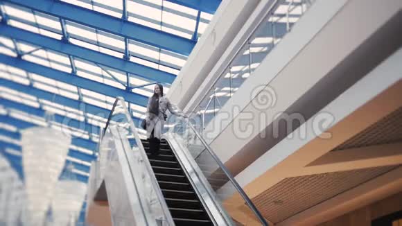 充满自信的优雅女商人站在自动扶梯上商场里的女孩视频的预览图