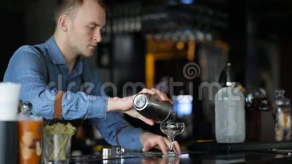 年轻的酒保和顾客沟通为他准备一杯鸡尾酒视频的预览图