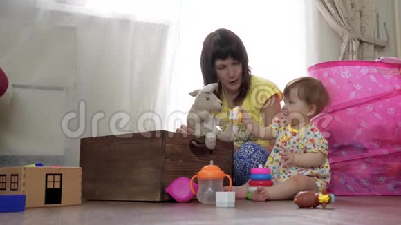 妈妈和一个小孩在地板上的房间里玩视频的预览图
