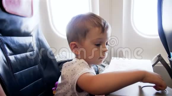 飞行过程中小男孩坐在飞机乘客座位上的4k视频视频的预览图