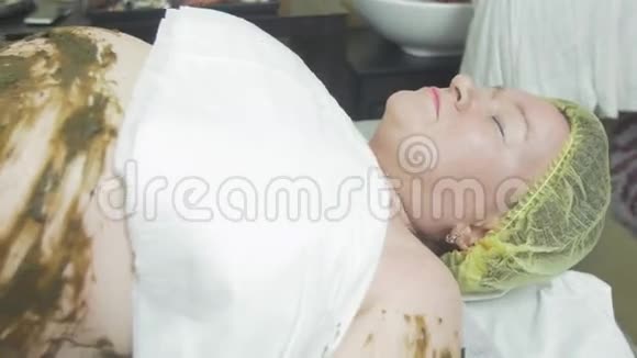 成年肥胖妇女躺在胃里左手水疗中心视频的预览图