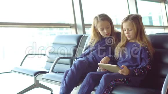 在机场等待登机和玩手提电脑的可爱小女孩视频的预览图