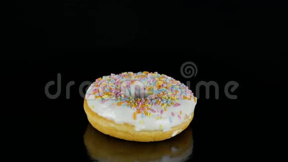 4K画面的糖衣甜甜圈带洒以慢速或慢速旋转黑色隔离视频的预览图