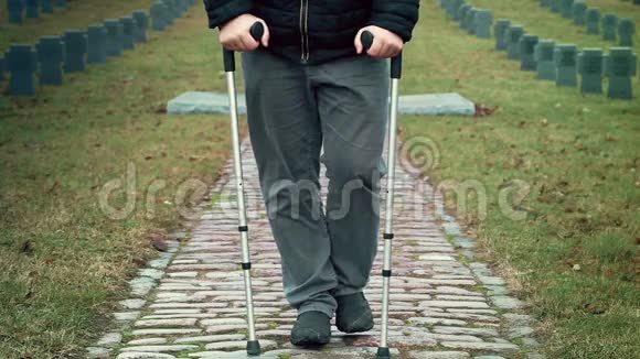 残疾退伍军人拄着拐杖离开墓地视频的预览图