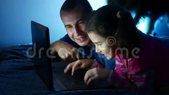 女孩和男人爸爸和女儿在笔记本电脑上工作玩网络娱乐游戏视频的预览图