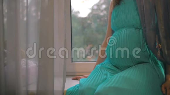 坐在窗台上拥抱的孕妇视频的预览图