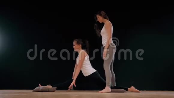 瑜伽教练帮助学生伸展肩膀快乐运动适合女孩视频的预览图