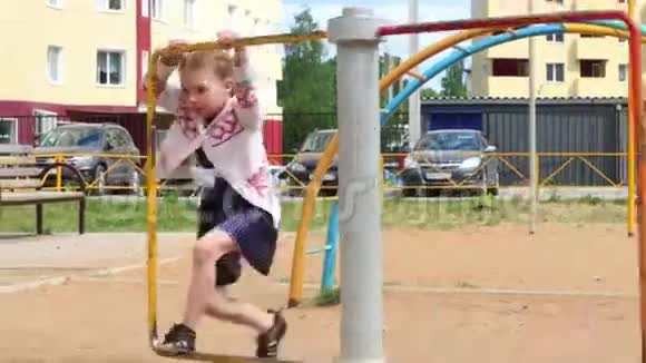 夏天穿着衣服的小女孩在儿童游乐场玩耍视频的预览图