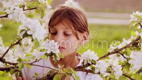 肖像特写白衣少年春园春天郁郁葱葱的花园里的白人男孩视频的预览图