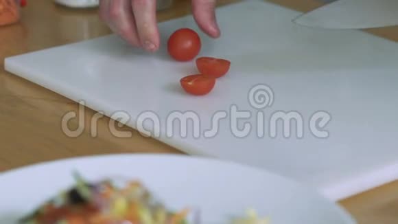 在餐厅厨房准备的切西红柿和樱桃的女人慢慢地视频的预览图