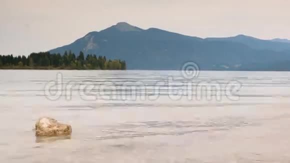 山湖水中石头的时间推移视频秋湖森林岛屿和山脉的温柔波浪视频的预览图