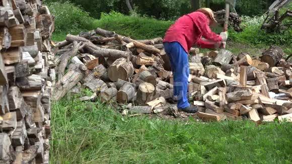 戴帽子的强壮园丁准备木材燃料和农村房屋4K视频的预览图
