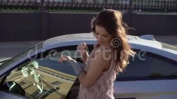 年轻女子在豪华跑车附近视频的预览图