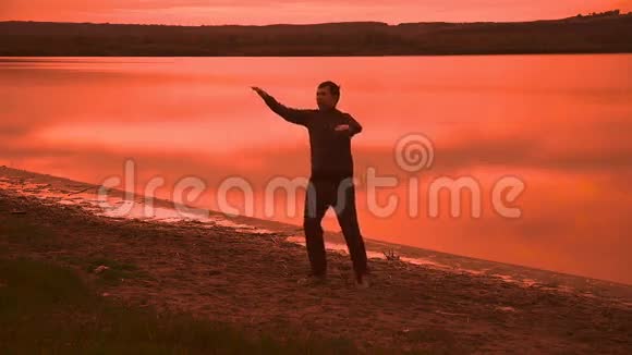 男子从事体操瑜伽的自然夕阳剪影红色运动视频的预览图