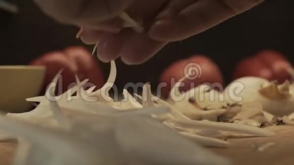 女性手在木制烹饪板上准备洋葱视频的预览图