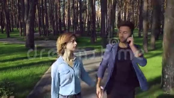 在公园里约会穿休闲装的高加索女孩牛仔衬衫穿蓝色时尚夹克的家伙视频的预览图