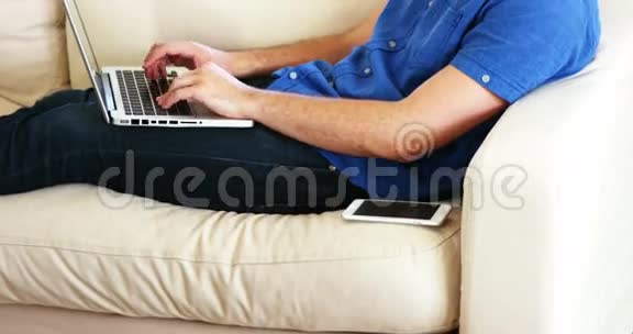 一个人坐在沙发上用手提电脑打电话视频的预览图
