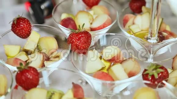 在一张白色桌子上放着草莓的玻璃杯里的水果庆祝活动视频的预览图