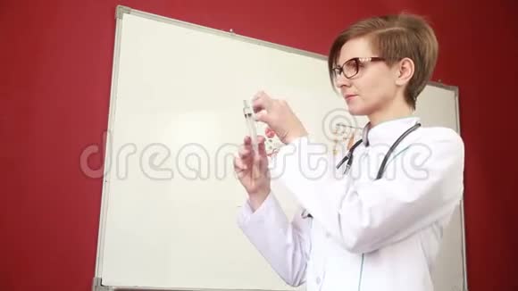 带着听诊器的女医生在实验室里看到注射器视频的预览图