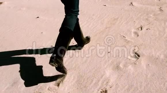 穿靴子的女人在沙滩上行走视频的预览图