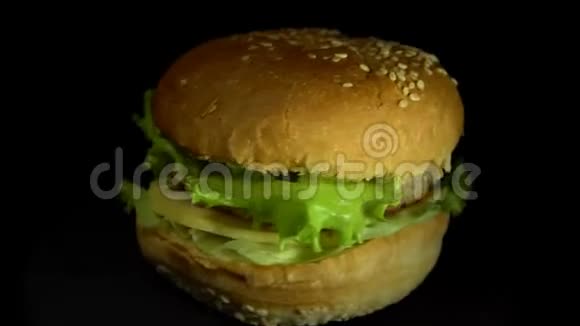 美味的芝士汉堡在黑色背景上旋转视频的预览图
