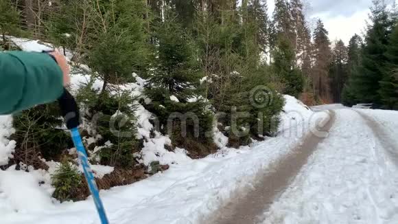 穿着夹克的女人和男人在冬天穿过一片雪林视频的预览图