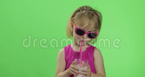 快乐的四岁孩子穿着粉红色的连衣裙喝奶昔鸡尾酒色度键视频的预览图