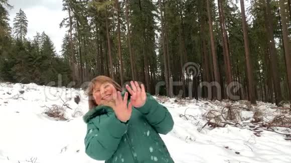 穿着夹克的女人和男人在冬天穿过一片雪林视频的预览图