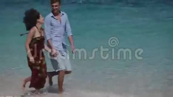 在热带海滩上奔跑的快乐夫妇视频的预览图