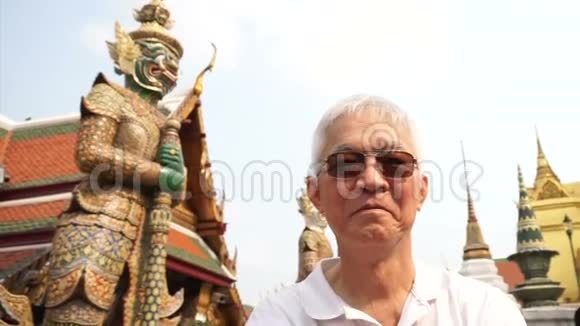 视频亚洲高级男子访问瓦特拉卡尤翡翠佛寺地标曼谷泰国视频的预览图