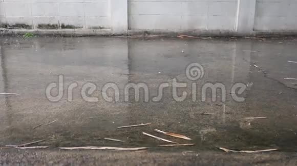 大雨倾盆地板水泥上的雨滴白墙背景视频的预览图