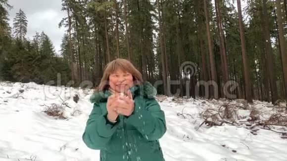 穿着夹克的女人和男人在冬天穿过一片雪林视频的预览图